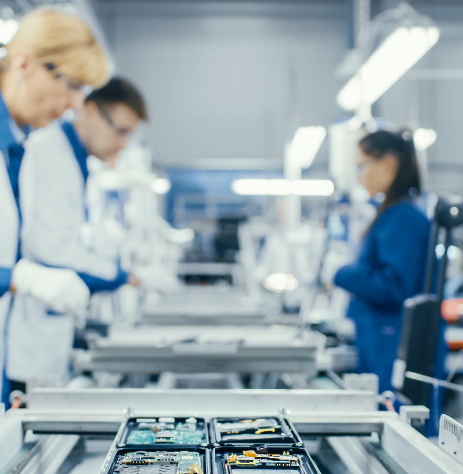 assembly line of a circuit board manufacturer shown with techs on the assembly line adding components
